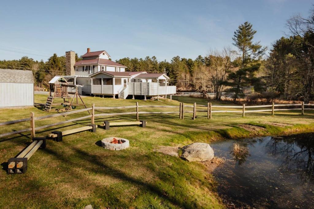 ein Haus mit einem Teich vor einem Haus in der Unterkunft Swan Pond Cabin Hot Tub & Firepit Retreat in Swan Lake
