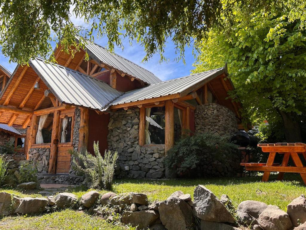 eine Blockhütte mit Metalldach in der Unterkunft Los Retoños in El Bolsón