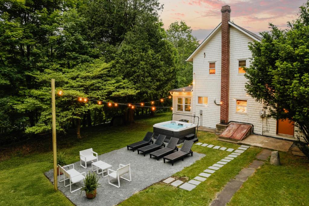 une arrière-cour avec une piscine, des chaises et une maison dans l'établissement Roebling House 1850s Cabin Hot Tub Fire Pit, à Lackawaxen