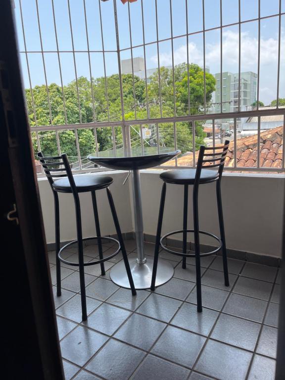 a table and two chairs in front of a window at Família Macapá in Macapá