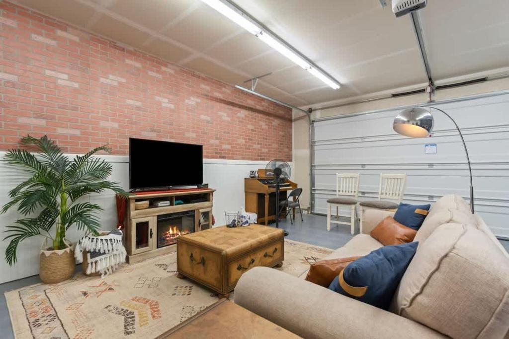 un salon avec un canapé et une télévision dans l'établissement Western Explorer Two Homes Sleeps 20, à Caldwell