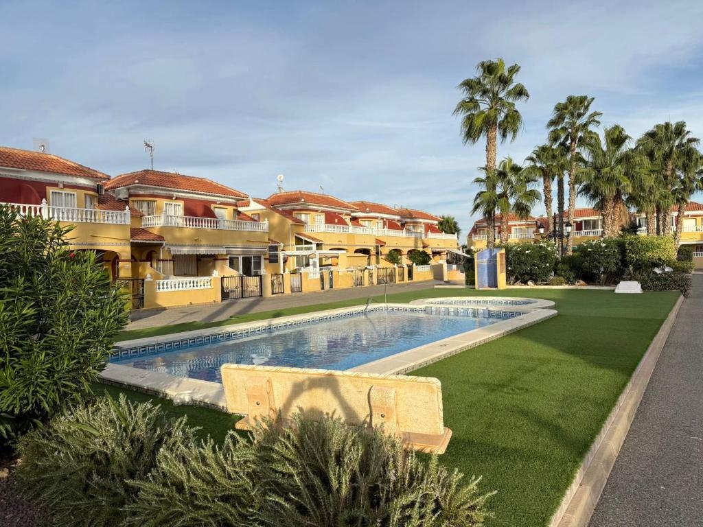 a resort with a swimming pool in front of a building at La Macarena Torrevieja in Torrevieja