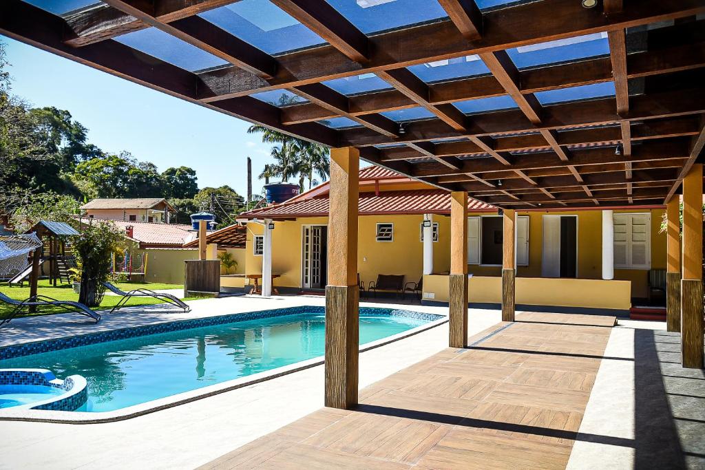 a pergola over a swimming pool in a house at Chácara no centro para até 15 pessoas com piscina aquecida e 5 quartos in Duas Barras