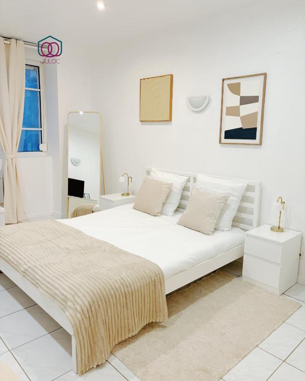 ein weißes Schlafzimmer mit einem großen Bett und einem Fenster in der Unterkunft Le Tiny Strasbourg - Adorable logement calme en plein coeur de la ville in Straßburg