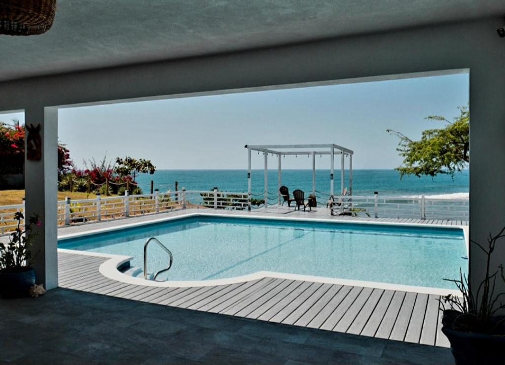 ein Swimmingpool mit Blick auf das Meer in der Unterkunft Beachfront villa with pool and staff in Treasure Beach