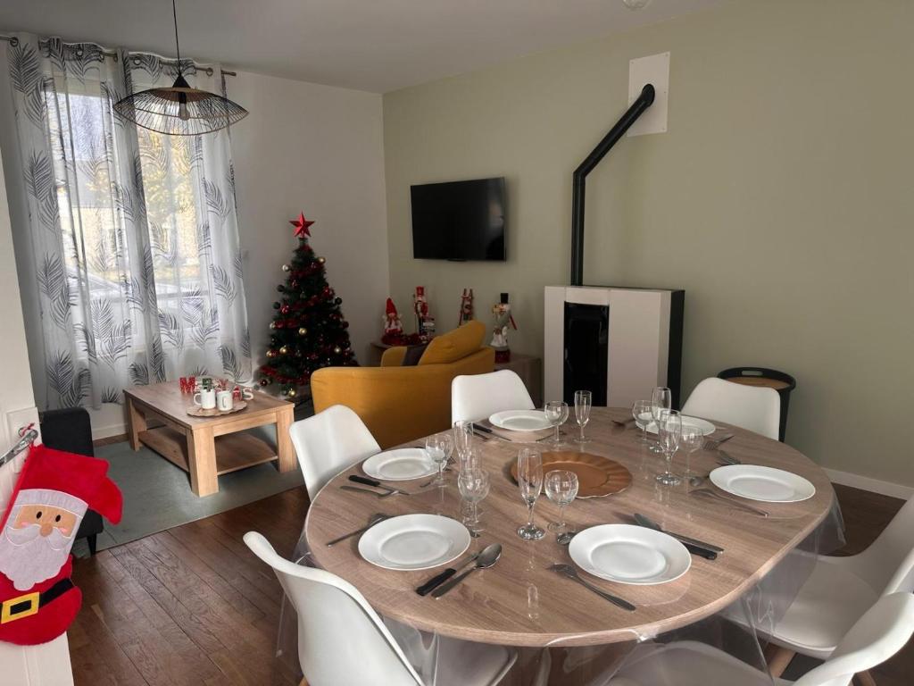 ein Esszimmer mit einem Tisch und einem Weihnachtsbaum in der Unterkunft Le Biardais - Gîtes du Bessin in Balleroy