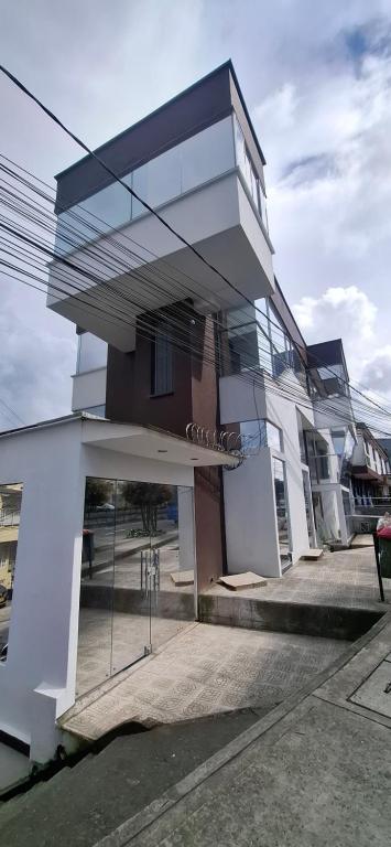 un edificio blanco con fachada de cristal en hotel portal del cerro manizalez, en Manizales