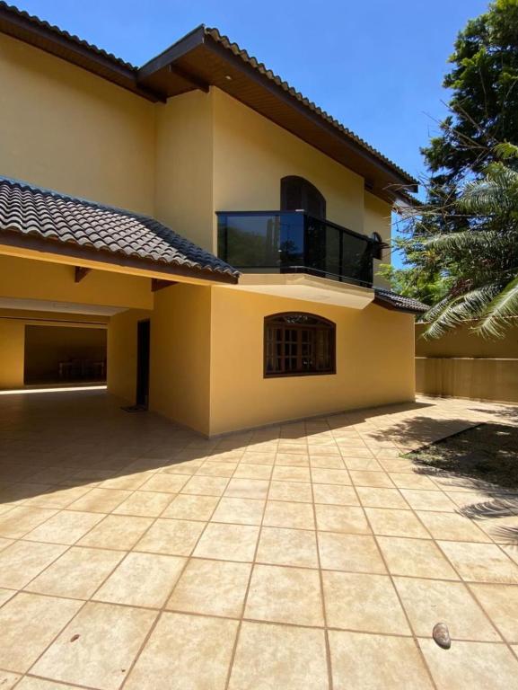 a house with a large patio in front of it at Sobrado Guaratuba 3 quartos in Guaratuba