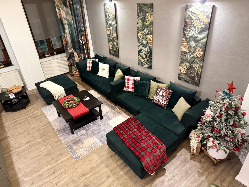 a living room with a green couch and a christmas tree at VOK Luxury Home I Tropical Living in Arad