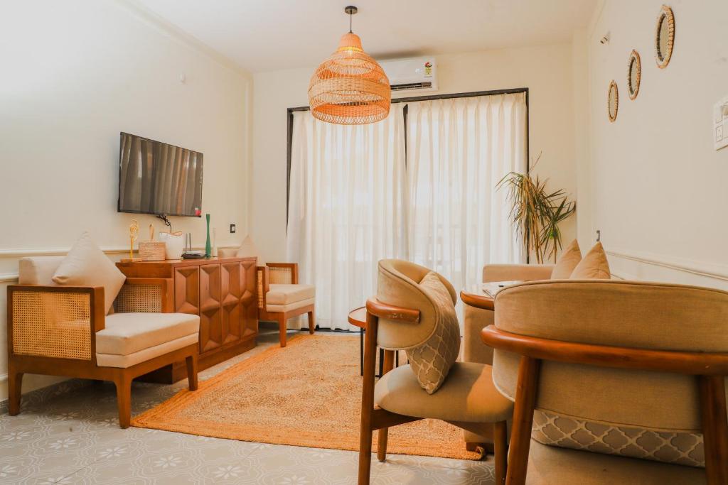 a living room with a dining table and chairs at Botanica Luxury 1BHK Apartment, Pool & Parking - Near Candolim Beach in Candolim