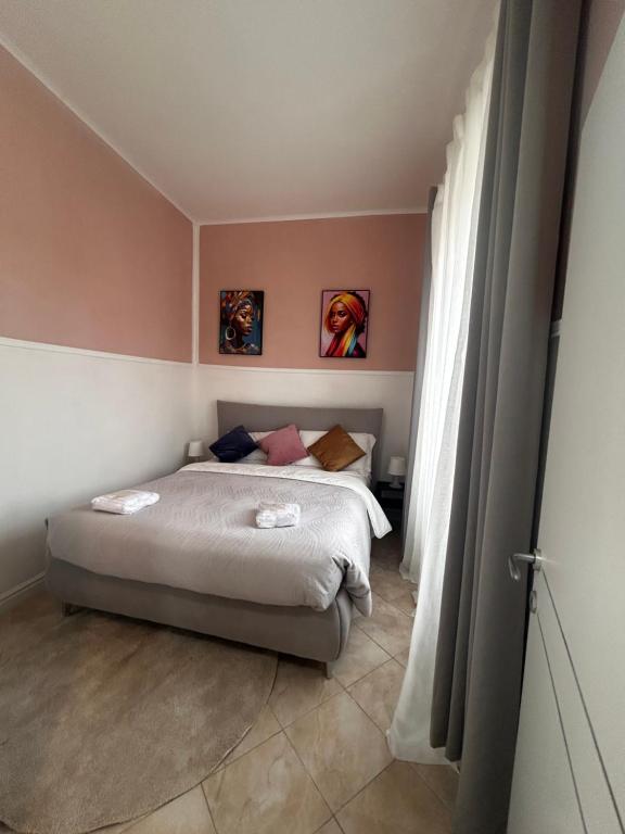 Un dormitorio con una cama y dos cuadros en la pared. en Speranza, en Grosseto
