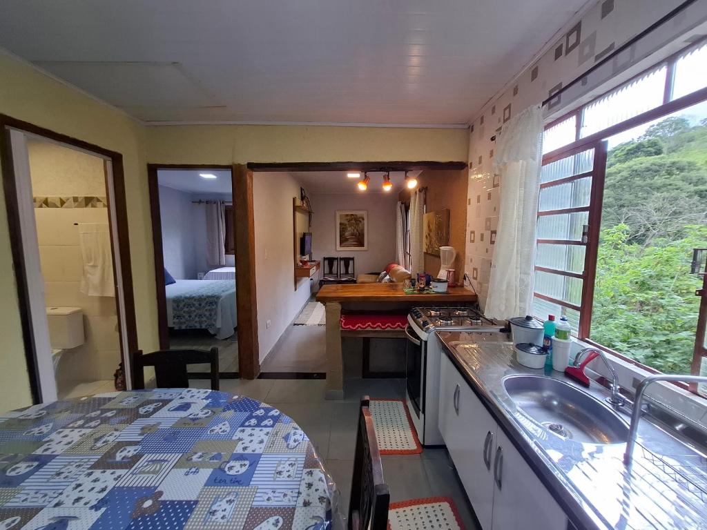 eine Küche mit Spüle und ein Badezimmer mit Bett in der Unterkunft Refugio na Natureza in Santo Antônio do Pinhal