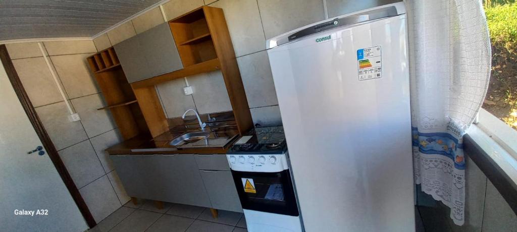 eine kleine Küche mit Kühlschrank und Spüle in der Unterkunft Casa do Aconchego in São Joaquim