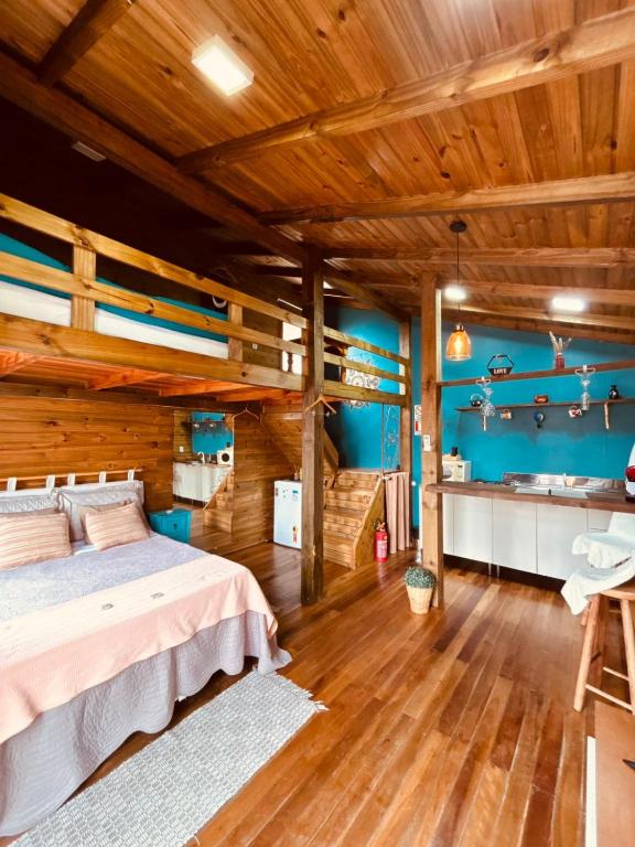a bedroom with a bed and a wooden ceiling at cabanas Aconchego dos Canyons in Praia Grande