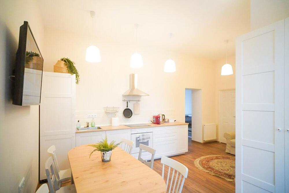 a kitchen with a wooden table and a dining room at Central Serenity near Piata Unirii in Oradea