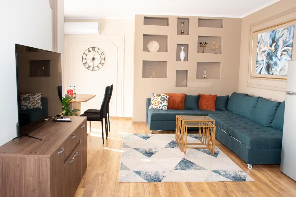 een woonkamer met een blauwe bank en een tafel bij Gondola Apartments Lux in Bansko