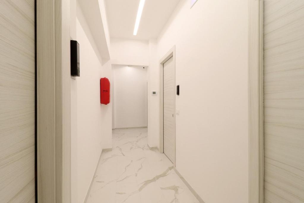 a hallway with white walls and a red phone on the wall at b&b la cattedrale in Avezzano
