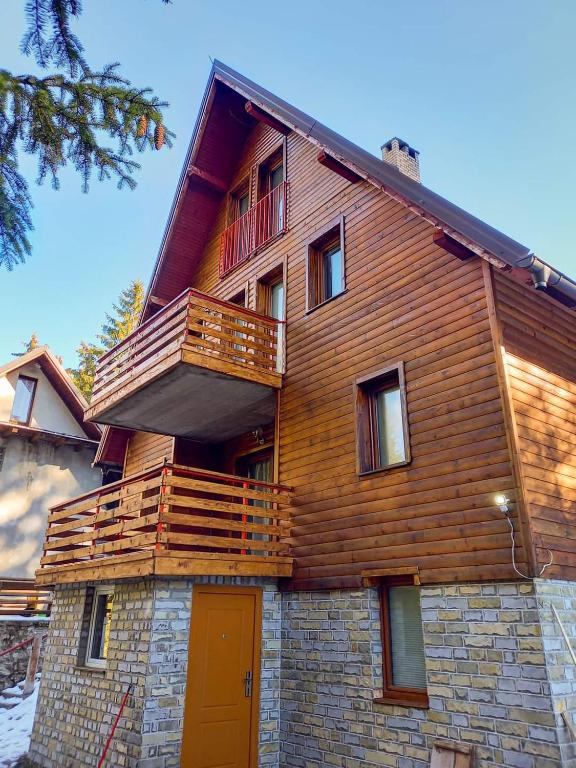 a wooden house with a deck on the side of it at Vikend kuća Libertas in Šišava
