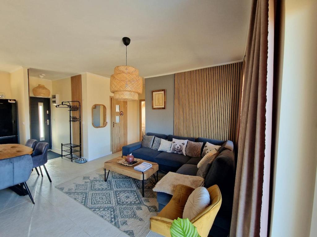 ein Wohnzimmer mit einem blauen Sofa und einem Tisch in der Unterkunft Chatka Niedźwiadka - domki w górach z widokiem na Beskid Niski i Sauną w cenie in Uście Gorlickie