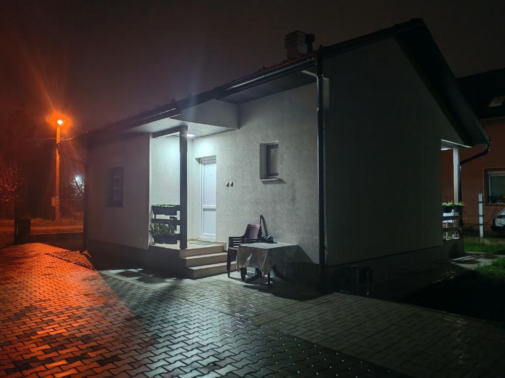 uma casa à noite com uma mesa e uma janela em Kuca za odmor SVETI LUKA SIMANOVCI em Šimanovci