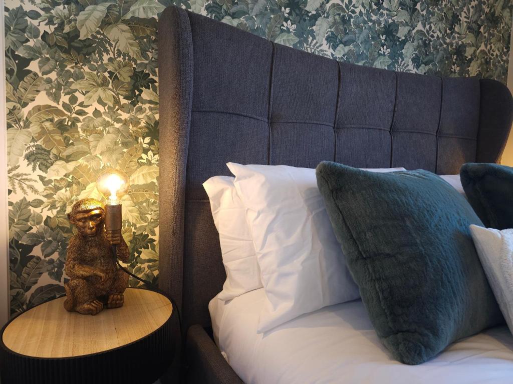 a lamp on a table next to a bed at STYLISH & SPACIOUS 4 BEDROOM HOUSE - FREE DRIVEWAY PARKiNG in Shrewsbury