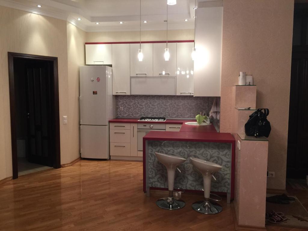 リヴィウにあるVirmenska Apartmentのキッチン(白いキャビネット、赤いカウンタートップ付)