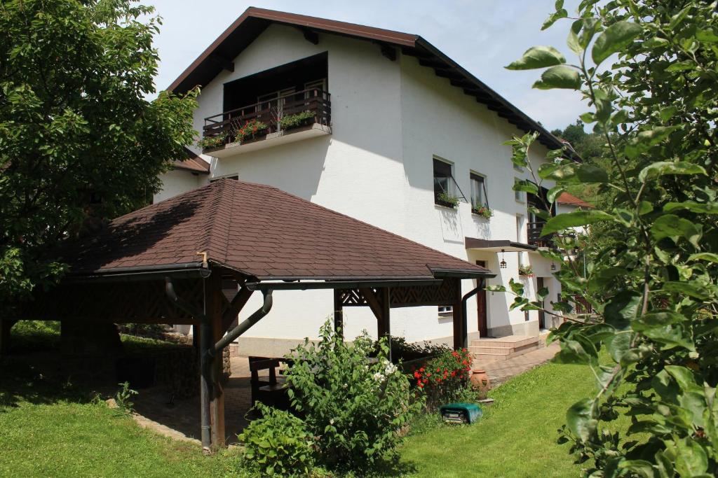 Biały dom z balkonem i dachem w obiekcie Vila Weekend w mieście Rogaška Slatina