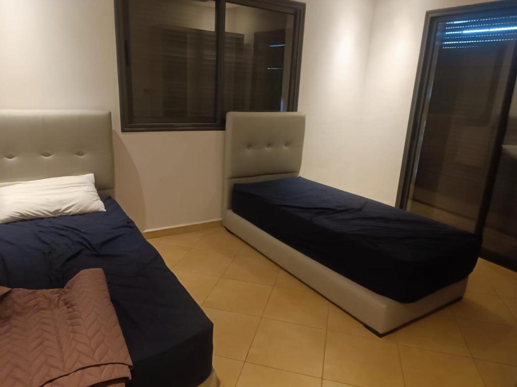 due letti in una stanza con una finestra di Résidence Ebla a Minaret de Mansuria