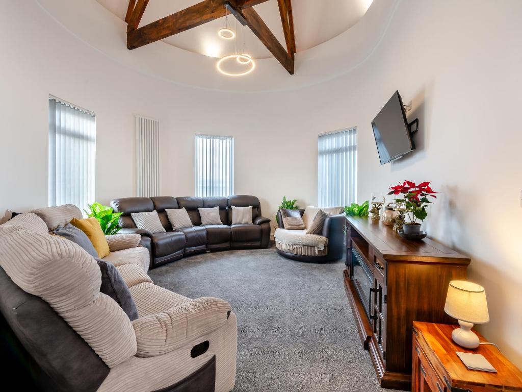 a living room with a couch and a tv at Sea View Penthouse - Regency Mansion in Redcar