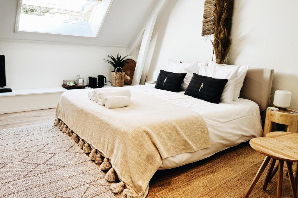 ein Schlafzimmer mit einem großen weißen Bett mit schwarzen Kissen in der Unterkunft B&B in woonboerderij vlakbij Lemmer in Rutten