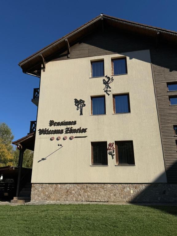 ein Gebäude mit einer Uhr an der Seite in der Unterkunft Vâlceaua Zânelor in Stațiunea Climaterică Sâmbăta