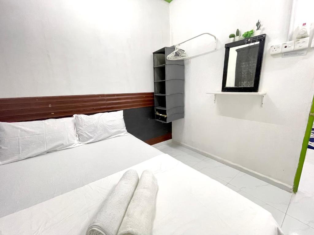 ein Schlafzimmer mit einem weißen Bett und einem Spiegel in der Unterkunft Homestay Bajet MokAji in Kuala Terengganu