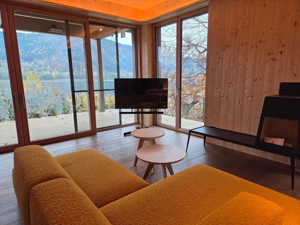 a living room with a couch and a flat screen tv at SeeZeit am Ossiacher See in Bodensdorf