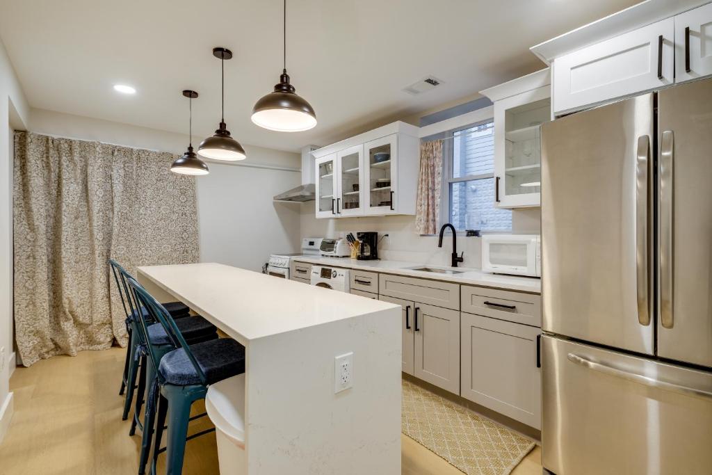 Una cocina con gabinetes blancos y encimera. en Walk to Metro and Dtwn Silver Spring! Sleek Apt, en Silver Spring