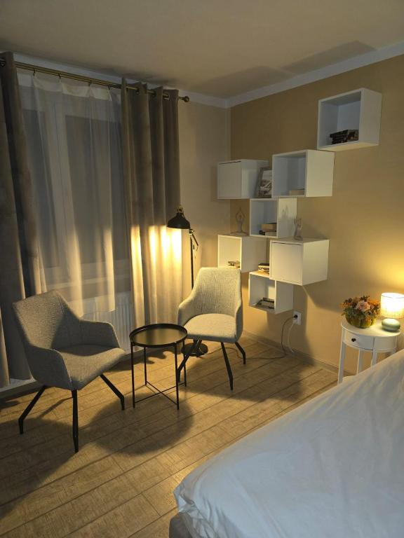 a hotel room with a bed and chairs and a table at Ingrid Residence in Ocna-Mureşului