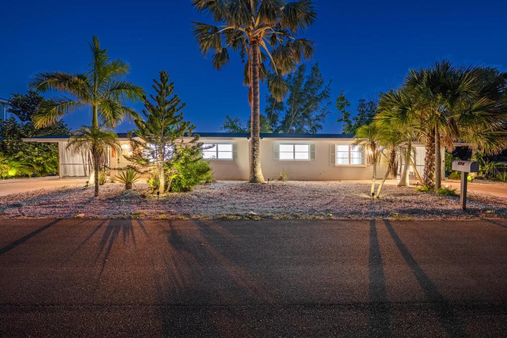 a house with palm trees in front of a street at Full Duplex on Longboat Key, Walk to the Gulf + Cedars East Club Access in Longboat Key