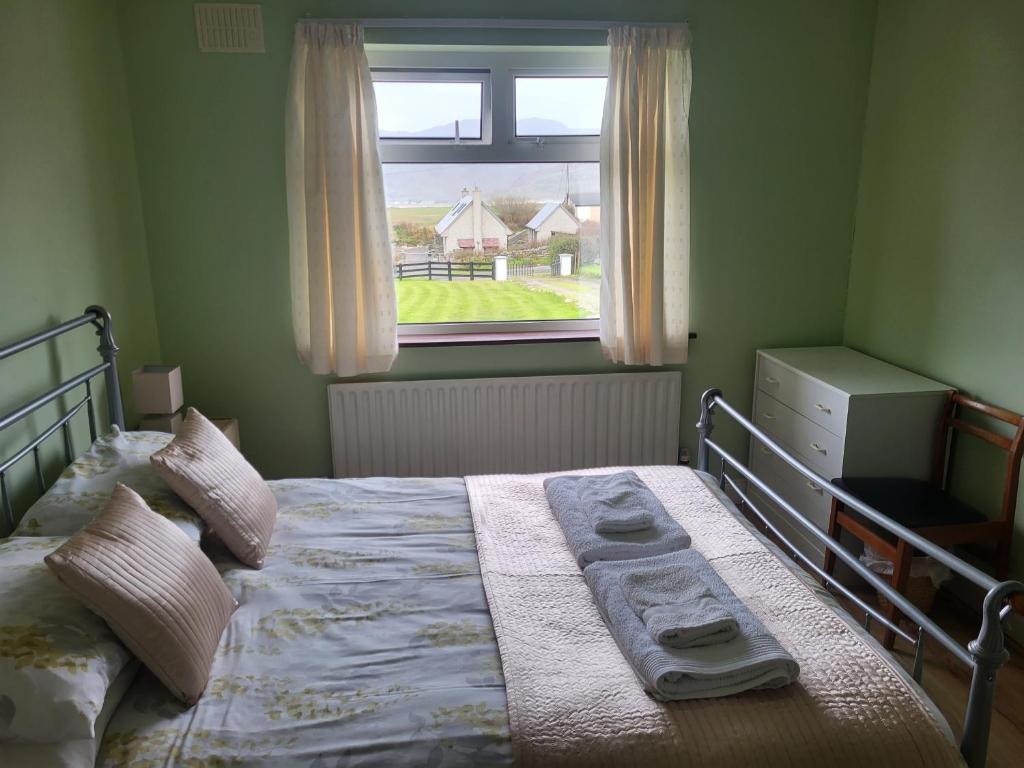 a bedroom with a bed with a window at Ard A Mhaoire in Glendorragha