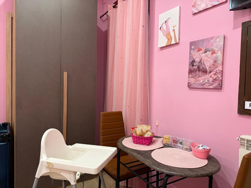 a pink room with a table and chairs at Giulieda in Magicland in Naples