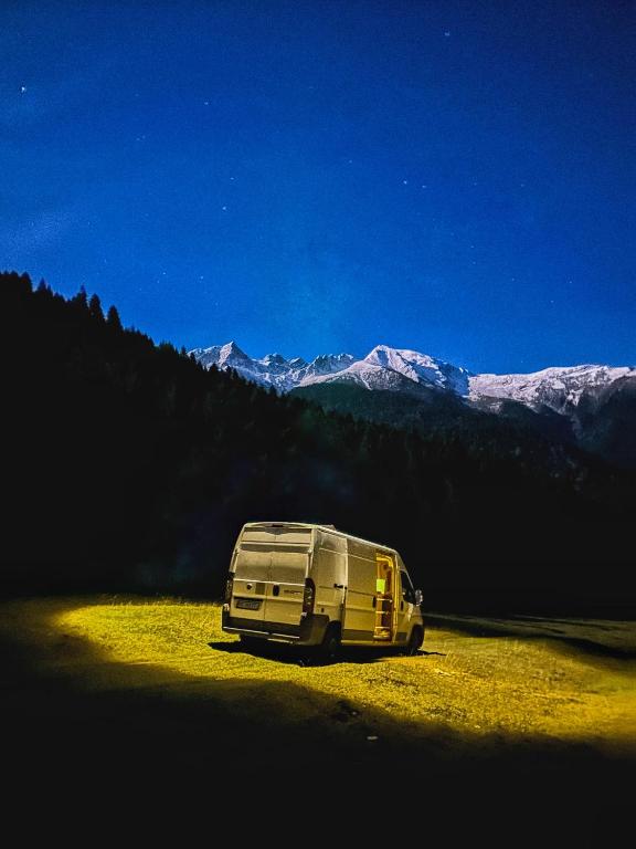 a van parked in a field with mountains in the background at campers georgia in Kutaisi