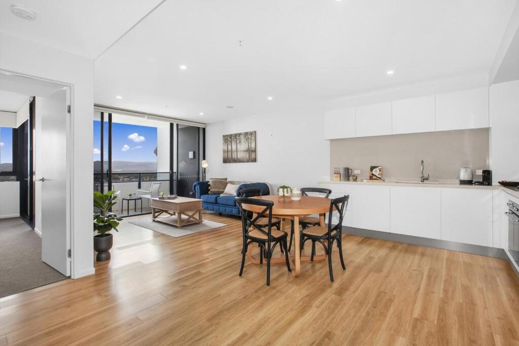 een keuken en woonkamer met een tafel en stoelen bij Azure View One-Bed in Gold Coast