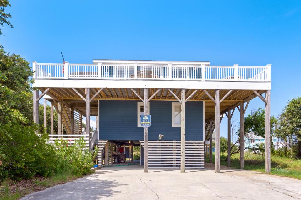 ein blaues Gebäude mit einer Terrasse darüber in der Unterkunft 1030 - La Ballena Cottage in Corolla