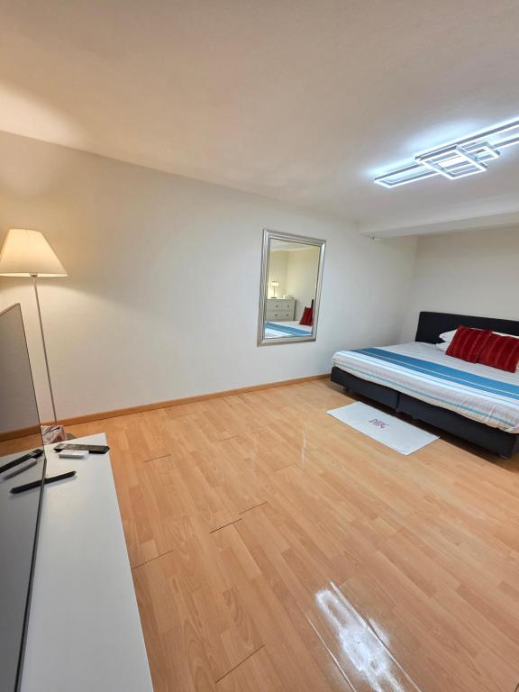 ein Schlafzimmer mit einem Bett und einem Holzboden in der Unterkunft Hello Zimmer in Brügg