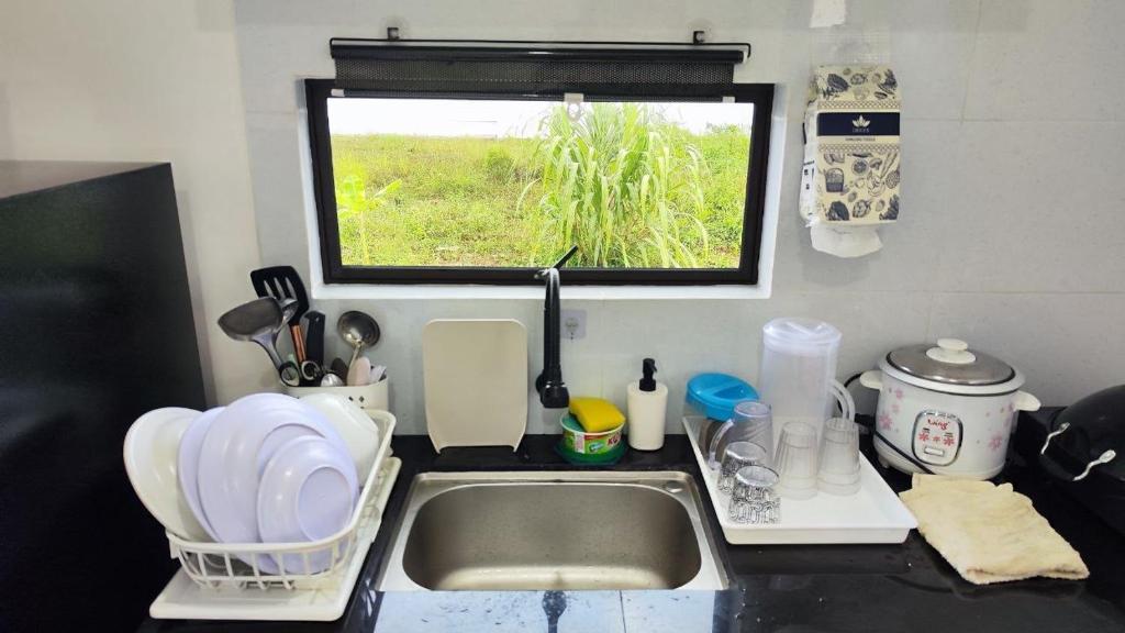 a kitchen counter with a sink and a window at Homestay Dataran Tikam Batu in Sungai Petani