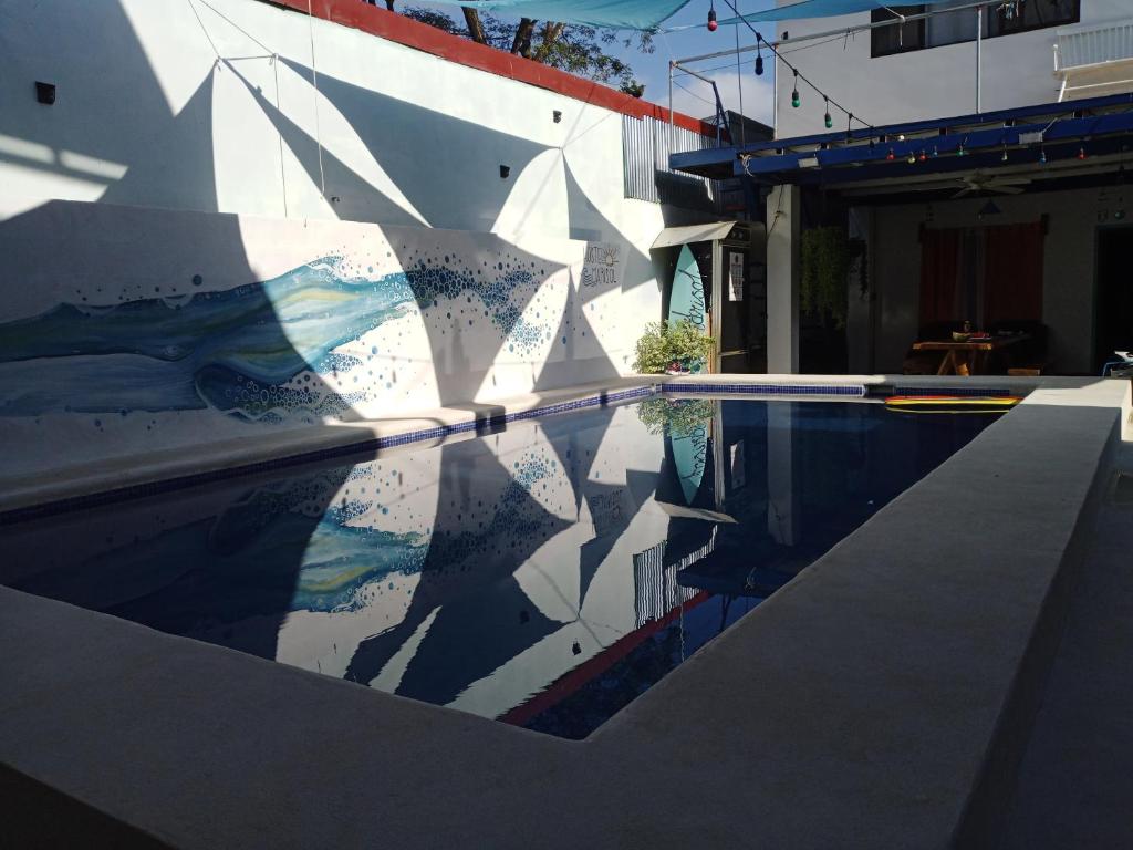 a swimming pool with a reflection of a building at Lodge Mar y Sol in Sámara