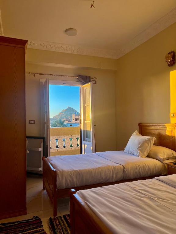 a bedroom with two beds and a large window at RAAK HOTEL فندق راك in Siwa