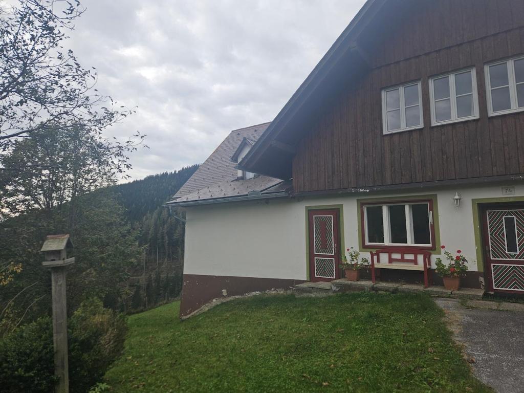a house with a gambrel roof and a yard at Gästehaus in ruhiger Lage zum Entspannnen in Sankt Kathrein am Offenegg