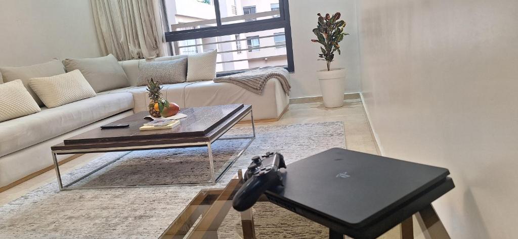 a living room with a couch and a table with a laptop at Central Marrakech Sunny Stay Poolside Apartment in Gueliz in Marrakech