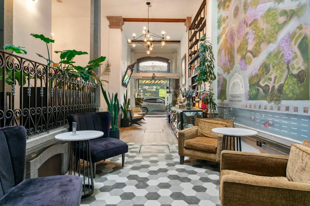 a restaurant with tables and chairs in a lobby at Casa Prim Hotel Boutique in Mexico City
