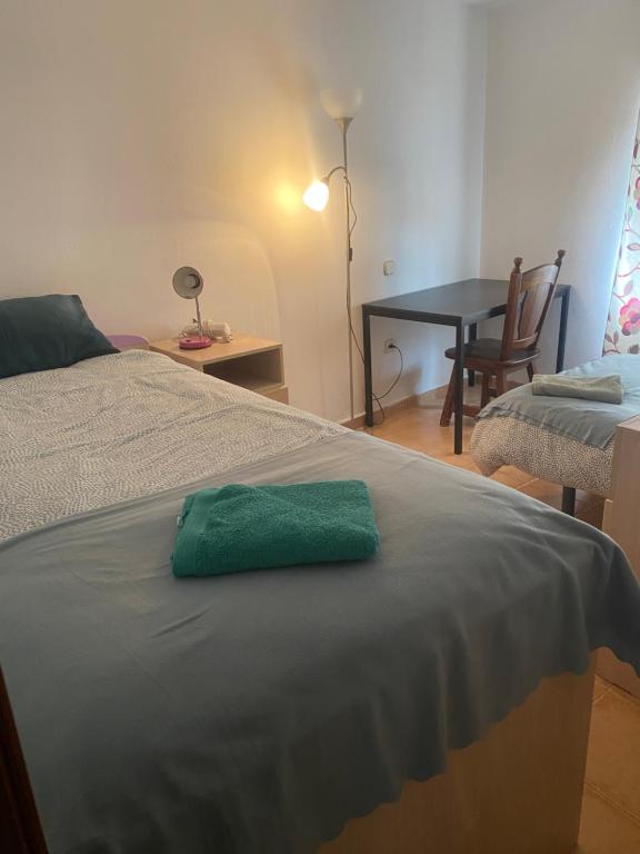 a green towel sitting on top of a bed at El Doblao del Rey in Torrejón del Rey