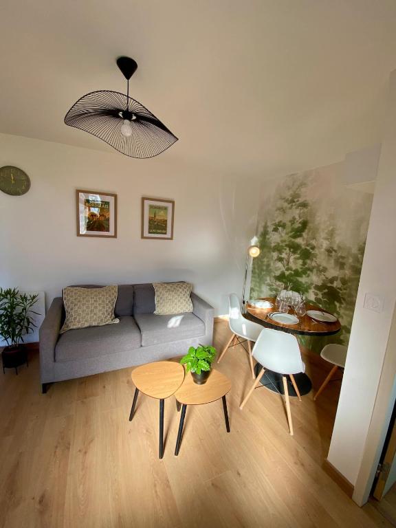 a living room with a couch and a table at COSY Dépendance proche Saint- Émilion in Le Fieu